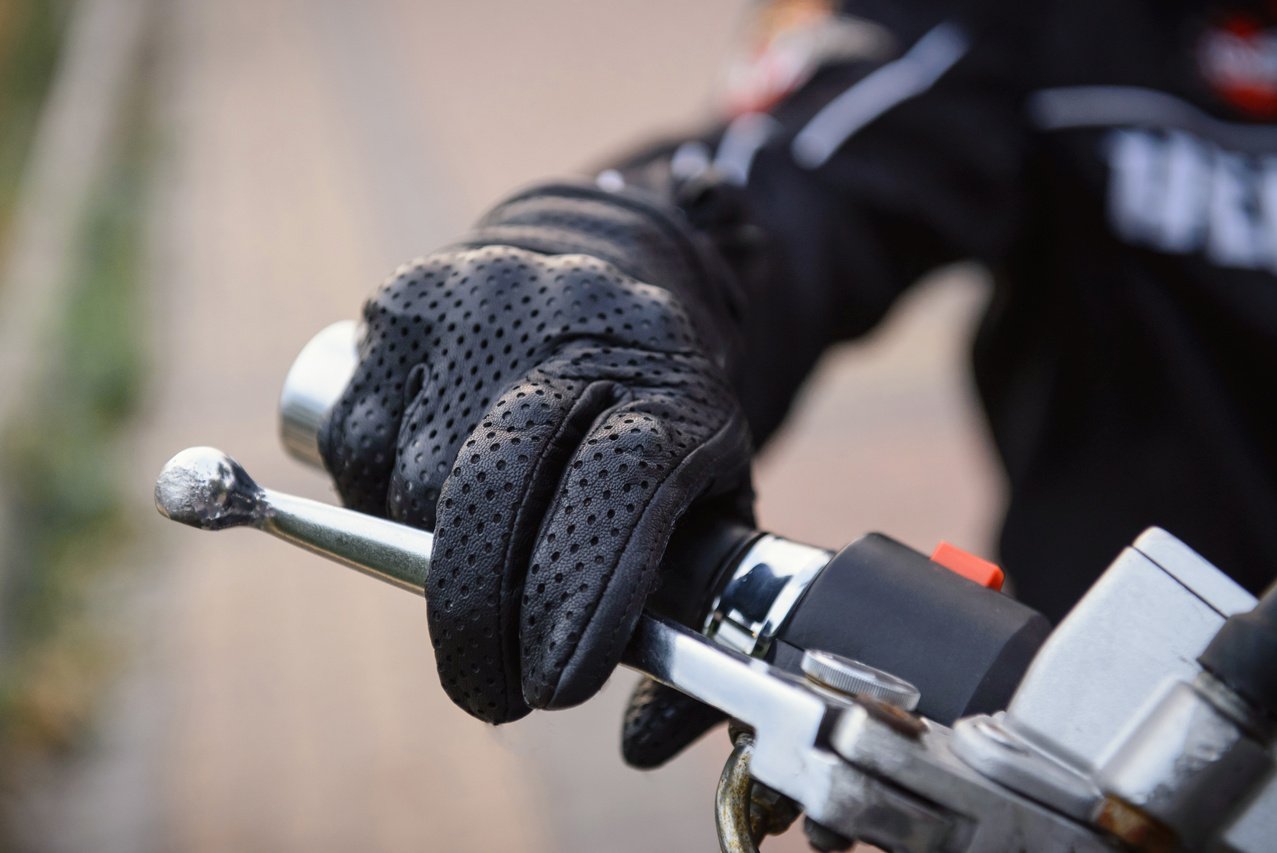 protective biker gloves on a motorcycle wheel